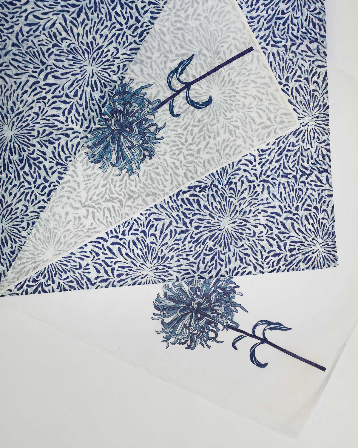 Overhead close-up of Chandramallika Dinner Napkins with blue chrysanthemum prints.