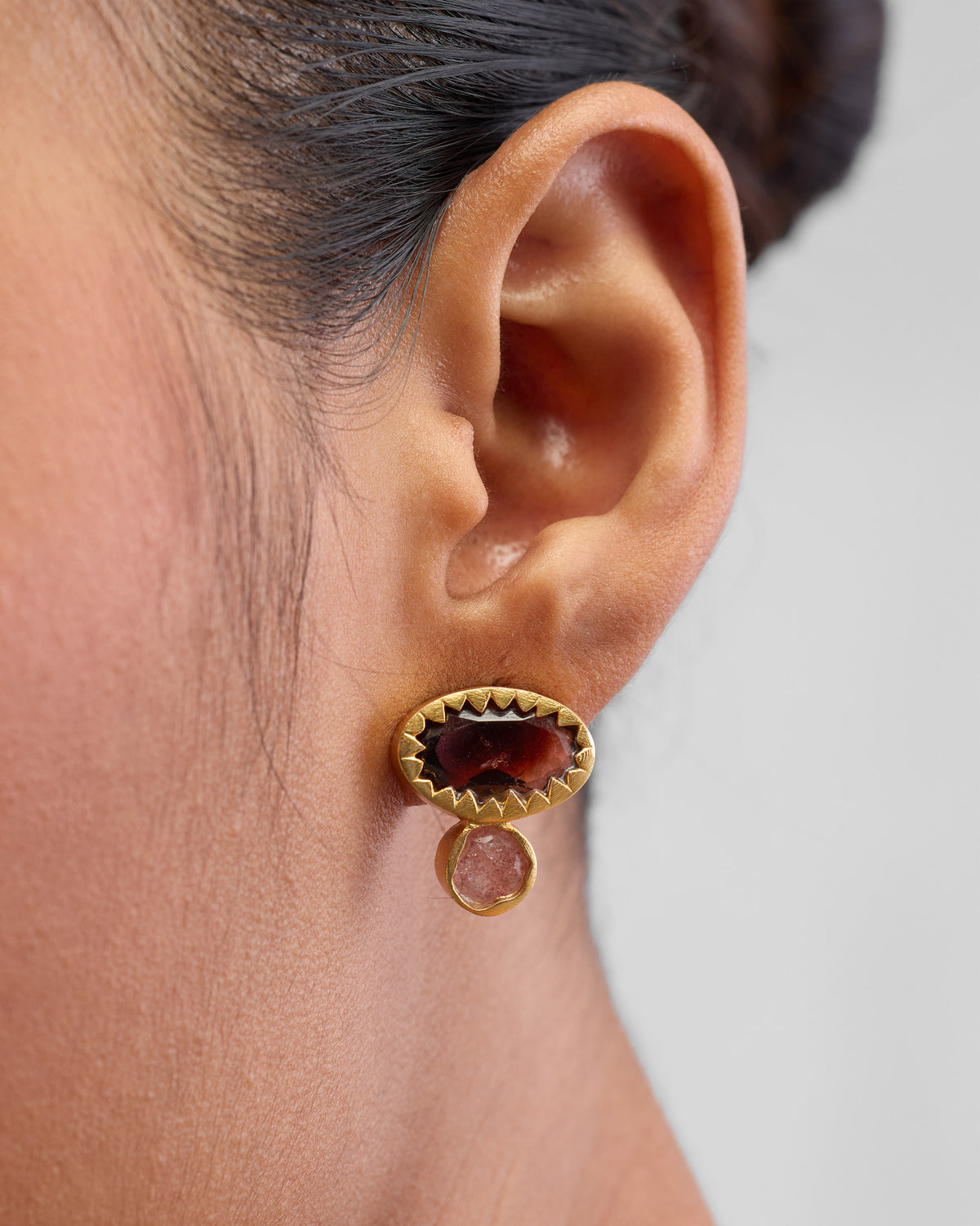 Close-up of Coastline Earrings worn, with a brown stone top and pink stone drop.