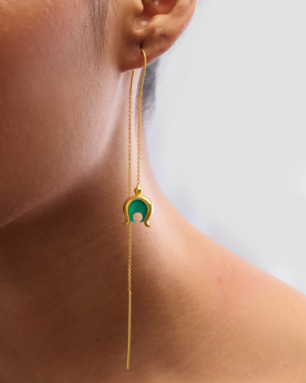 Side profile of a gold Chandphool sui dhaga earring with a green onyx crescent.
