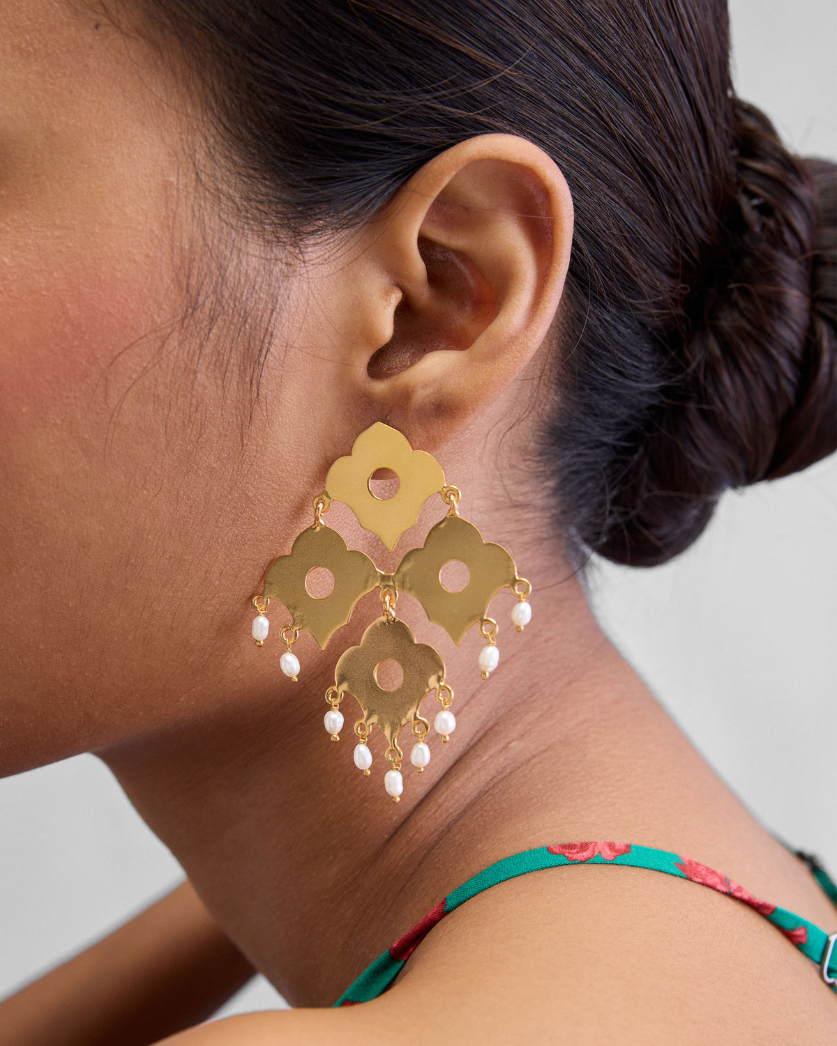 Person wearing gold Phool Jaal Earring with flower-shaped plates and pearl drops.