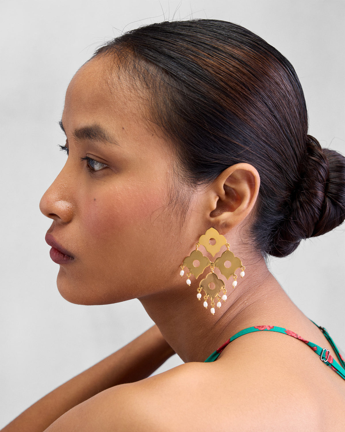 Side view of gold Phool Jaal Earring worn on a person.