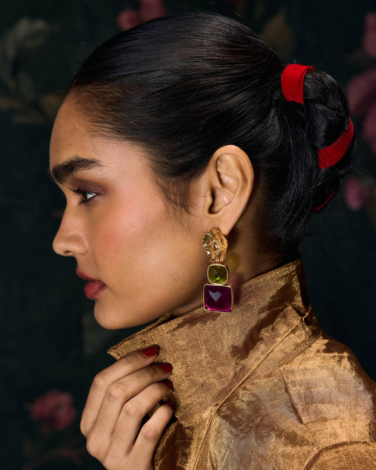 Side profile of gold dessert rose drops with green and magenta stones.