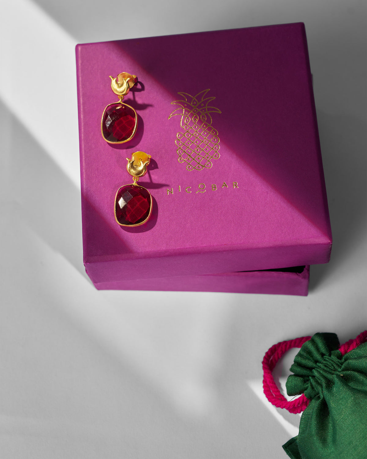 Pair of Chandphool Earrings displayed on a magenta gift box.