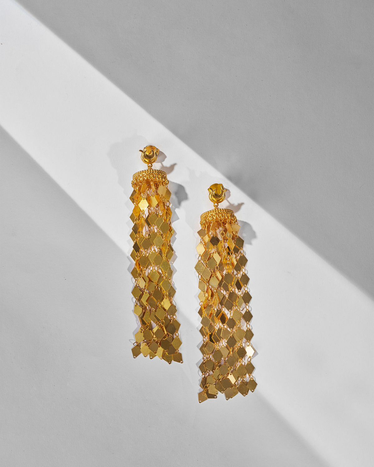 Gold Gulbahar earrings showing linked diamond-scale strands from textured caps.