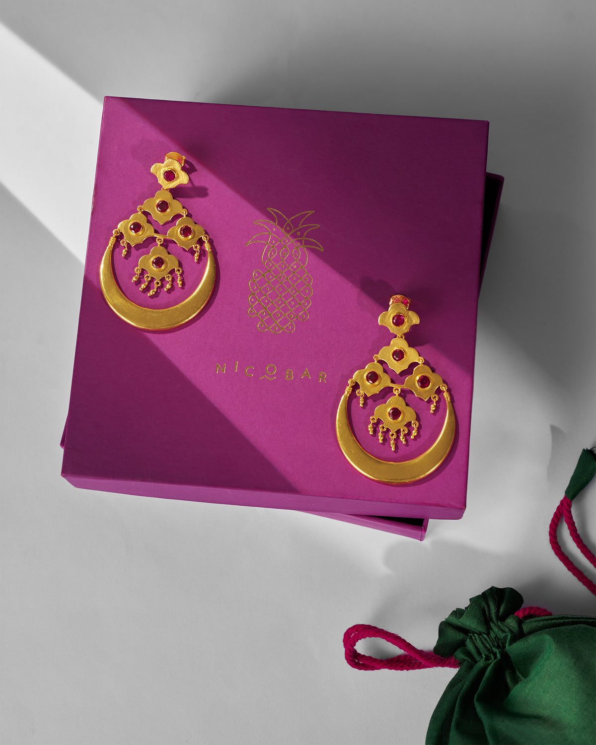 Gold Moon Flower earrings on a purple Nicobar gift box.