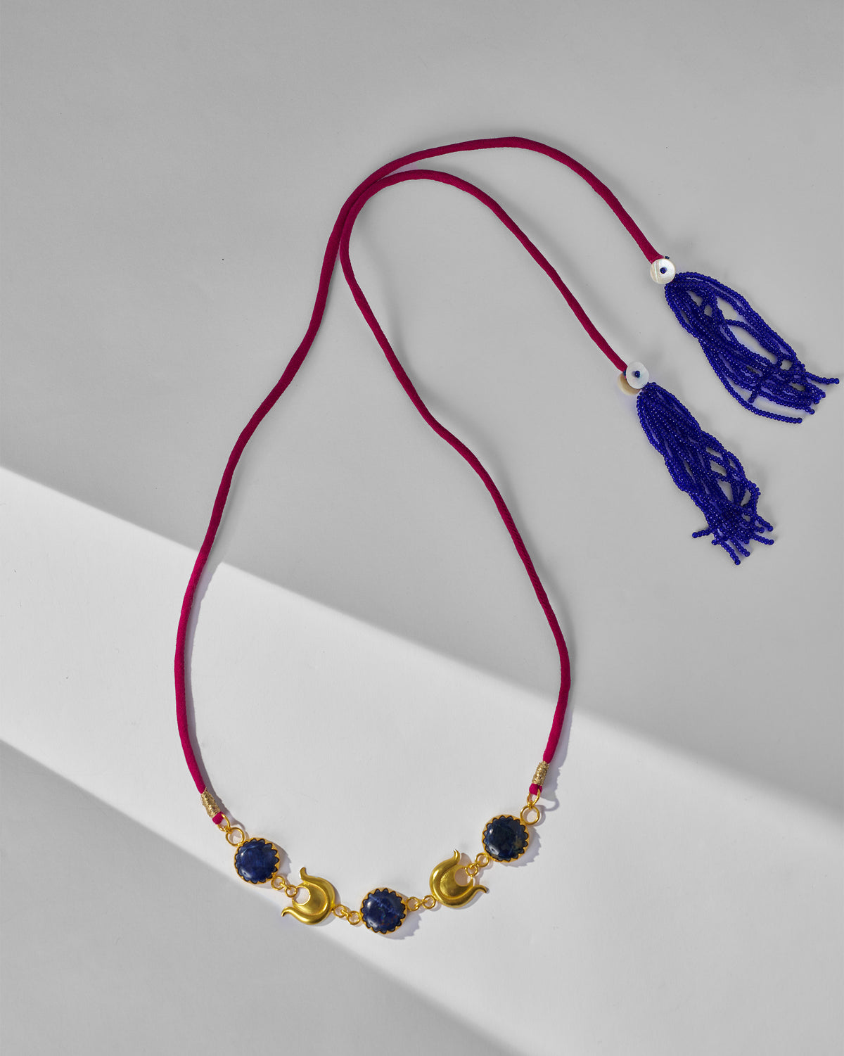 Chandphool Choker laid flat with its pink cord and tassels.