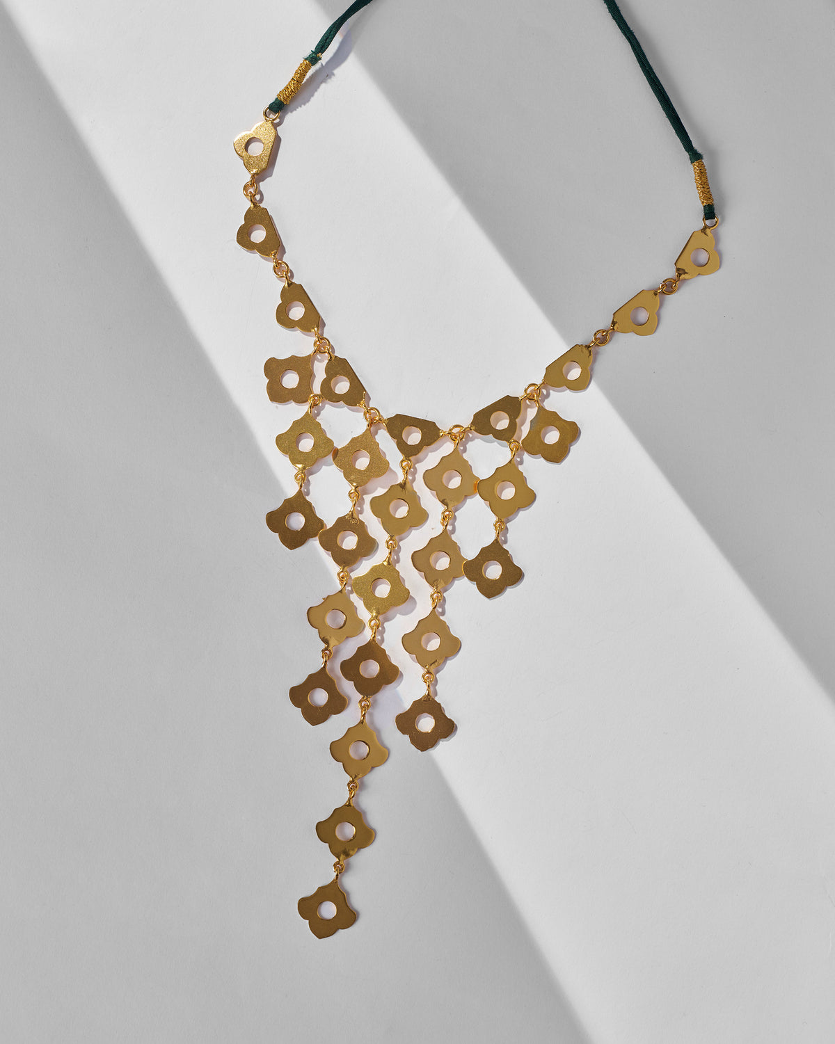 Gold Phool Jaal bib necklace showing linked four-petal flower lattice.