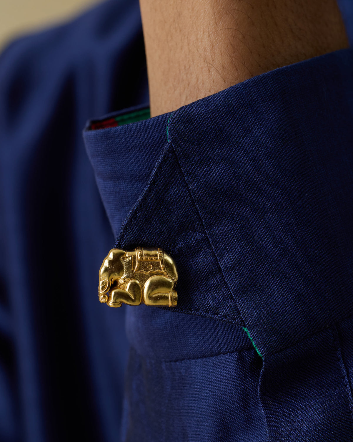 Close-up of Appu Cufflinks showing a gold elephant motif on a navy shirt cuff.