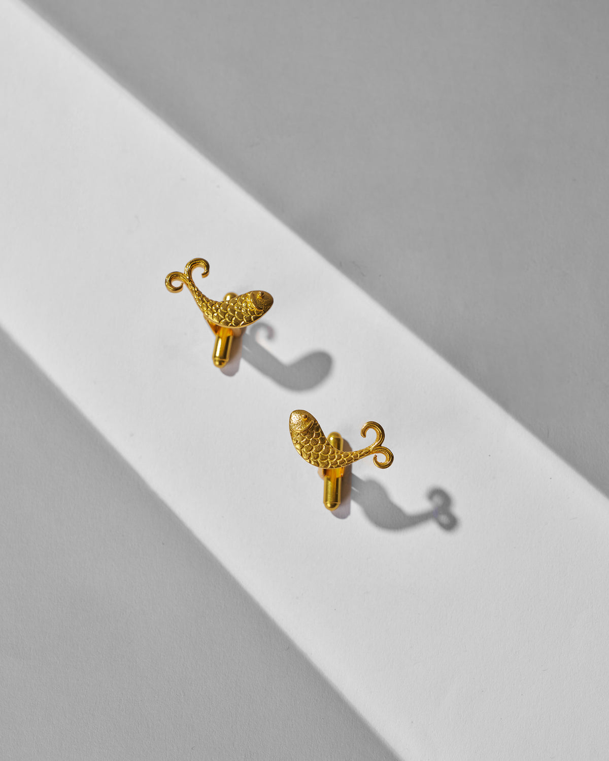 Pair of gold Jalpari Cufflinks laid flat.