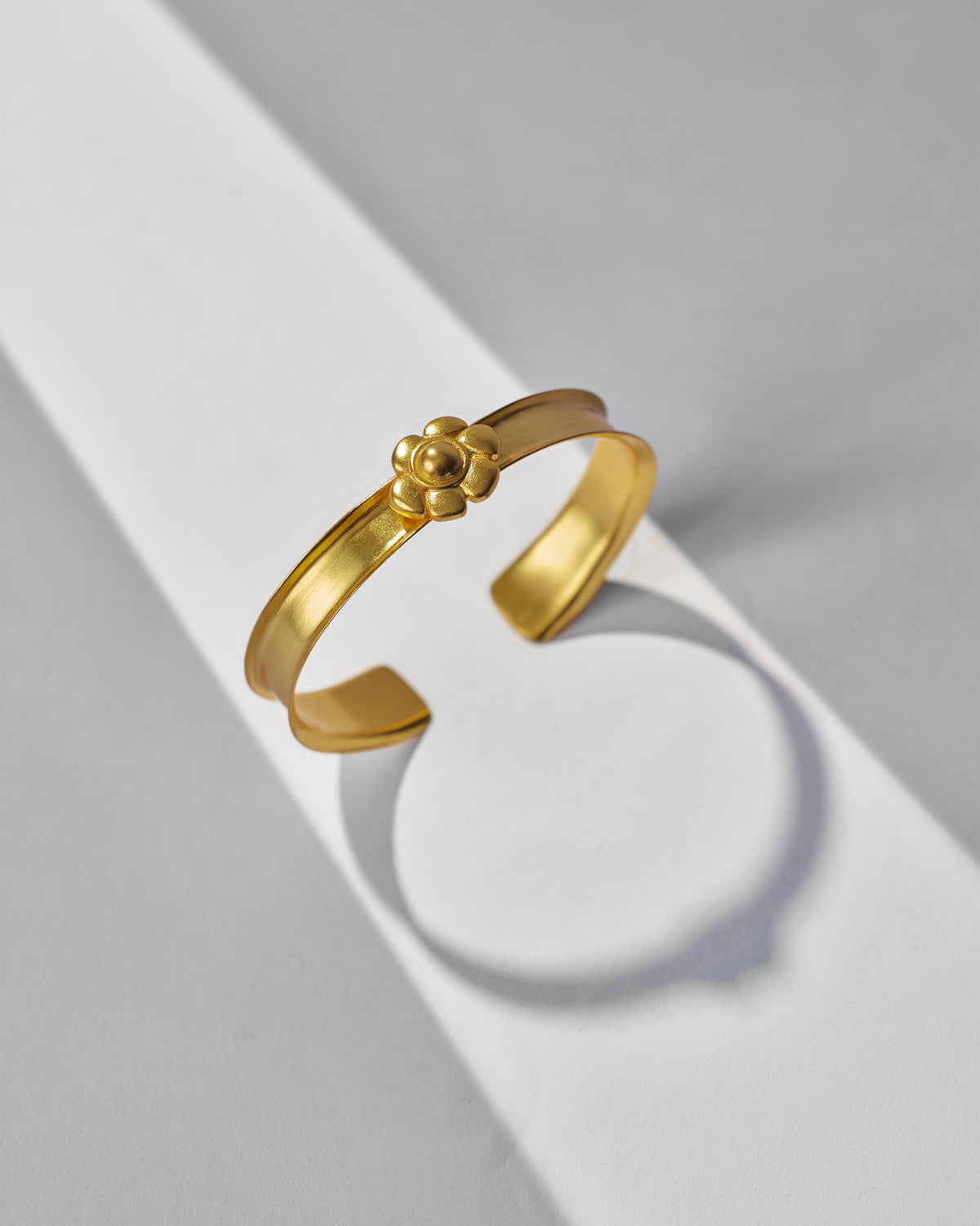 Clover Cuff shown open, with a raised flower motif at the centre.
