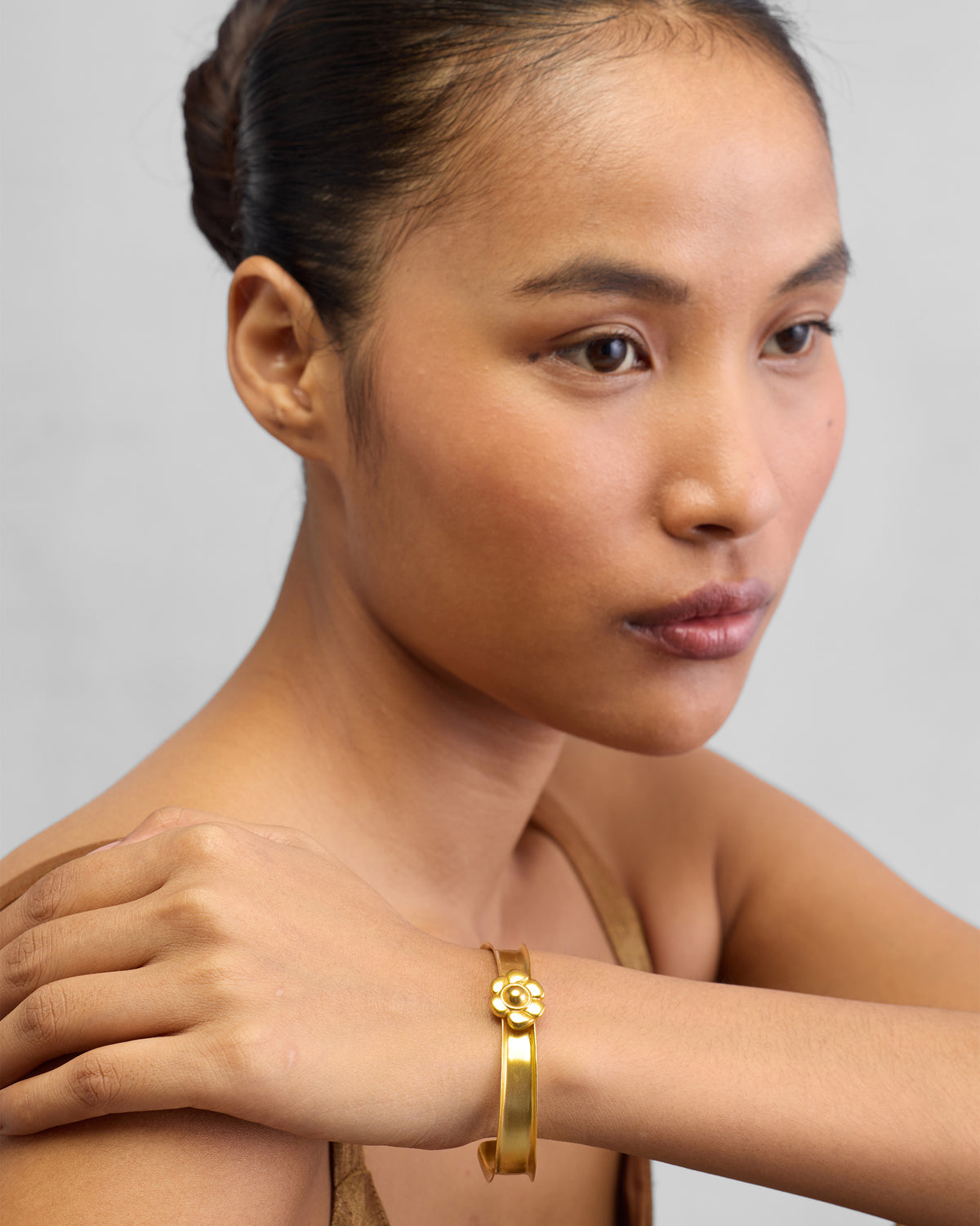 Person wearing Clover Cuff on the wrist, with the flower motif on top.