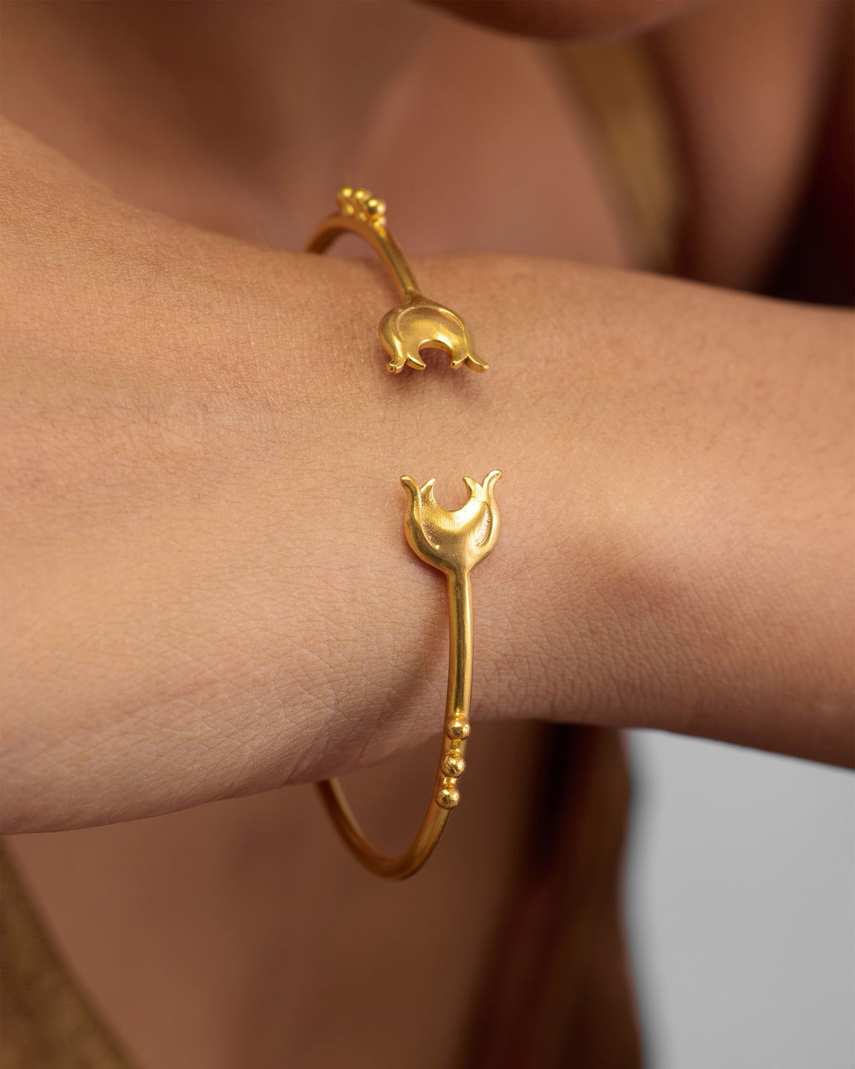 Person wearing Chaandphool Cuff, an open gold cuff with crescent-shaped ends.