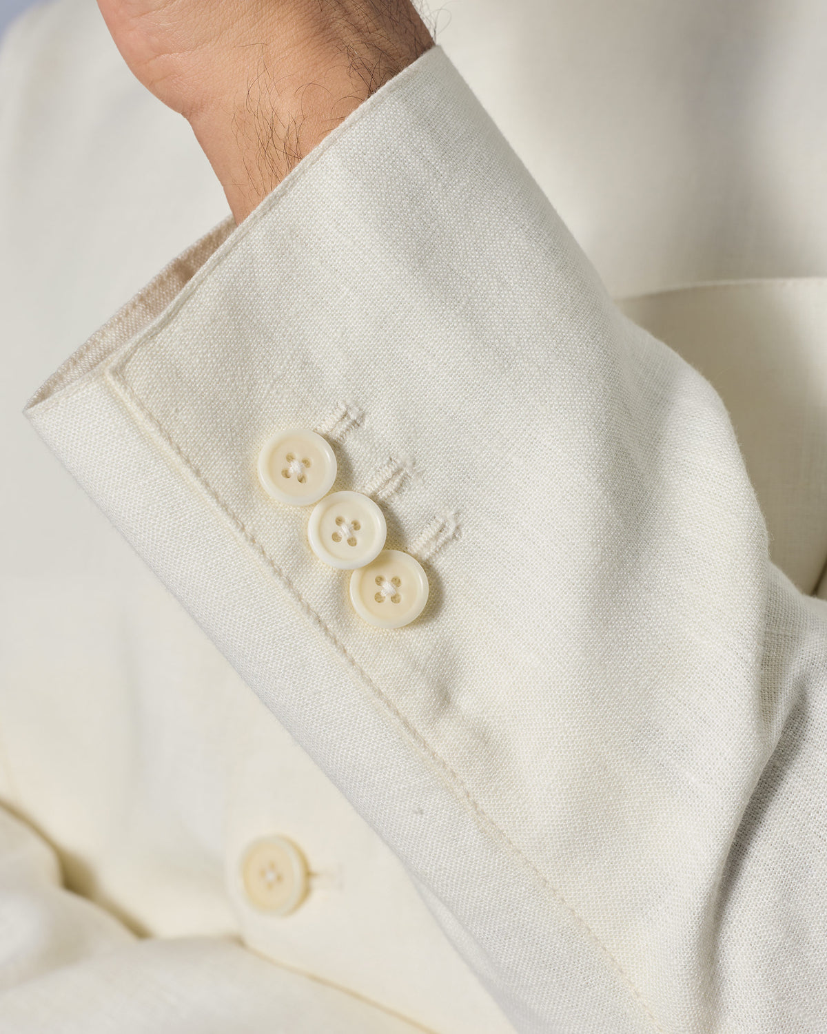 Close-up of the Tahr Bandhgala sleeve cuff showing three cream buttons.