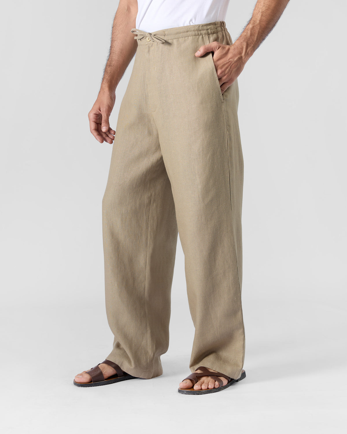 Sand Ibex trousers worn at a three-quarter angle showing the relaxed drape.