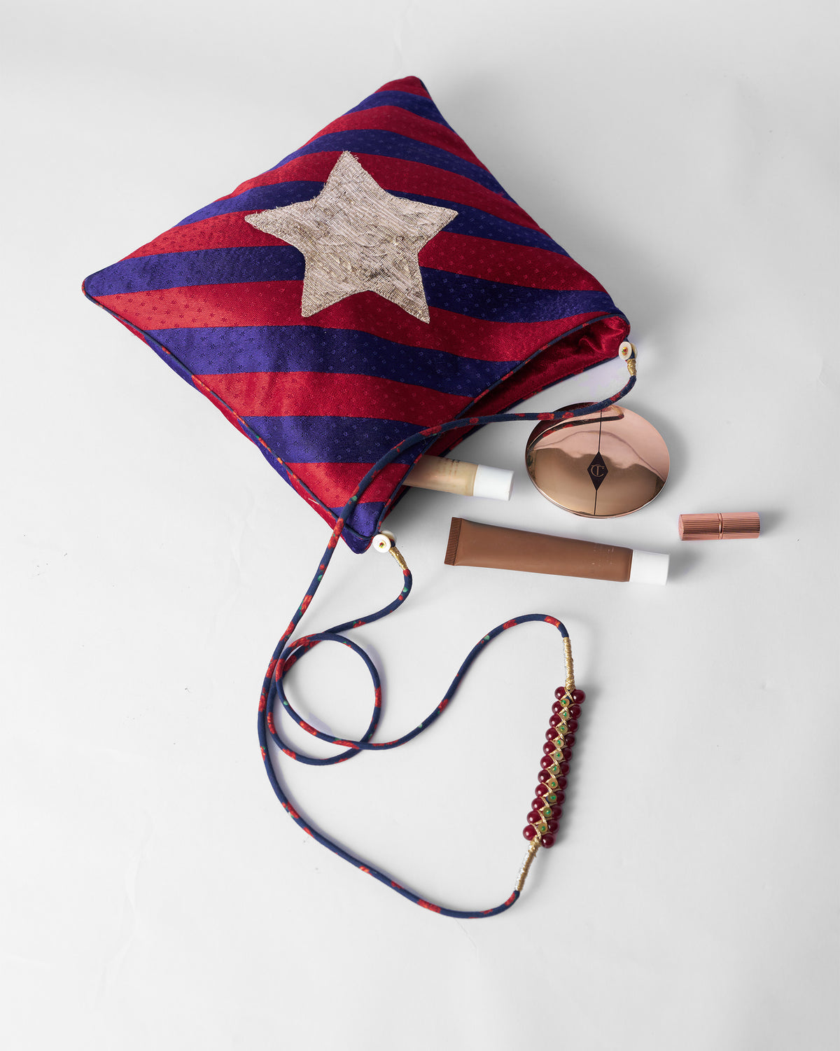 Red and purple Muris Sling packed with small everyday essentials.