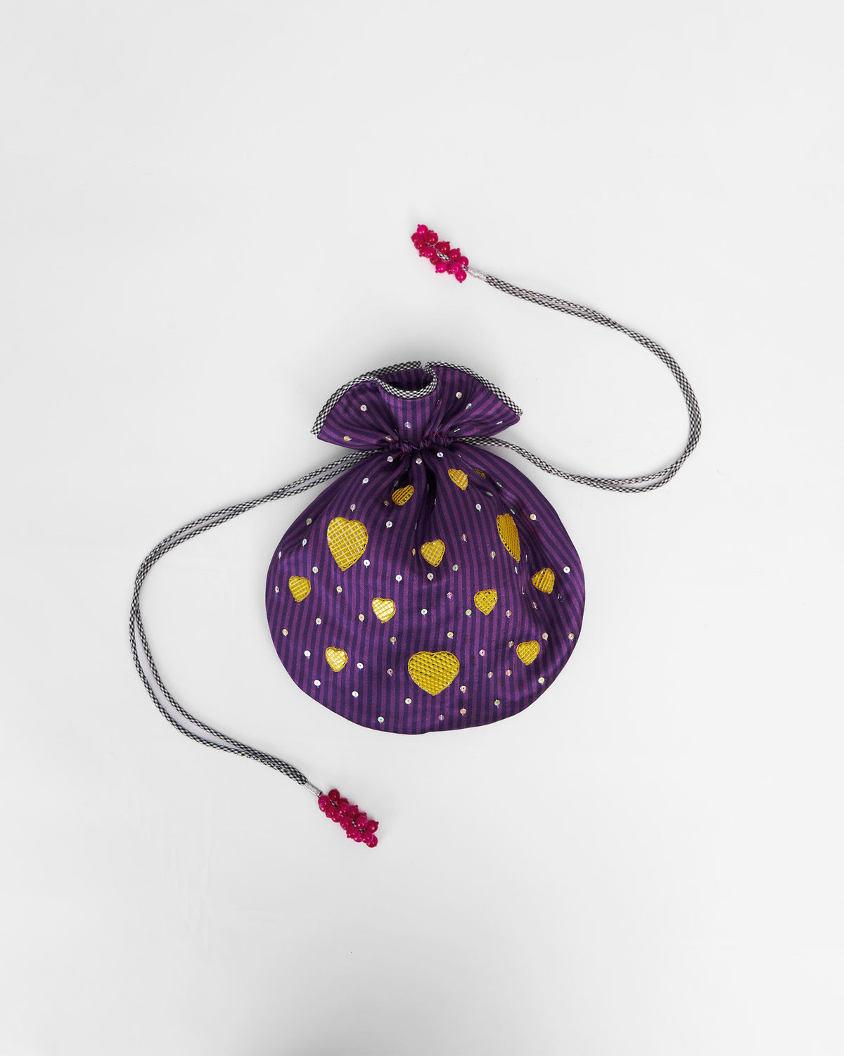 Violet Meher Potli laid flat with gold heart motifs and drawstring.
