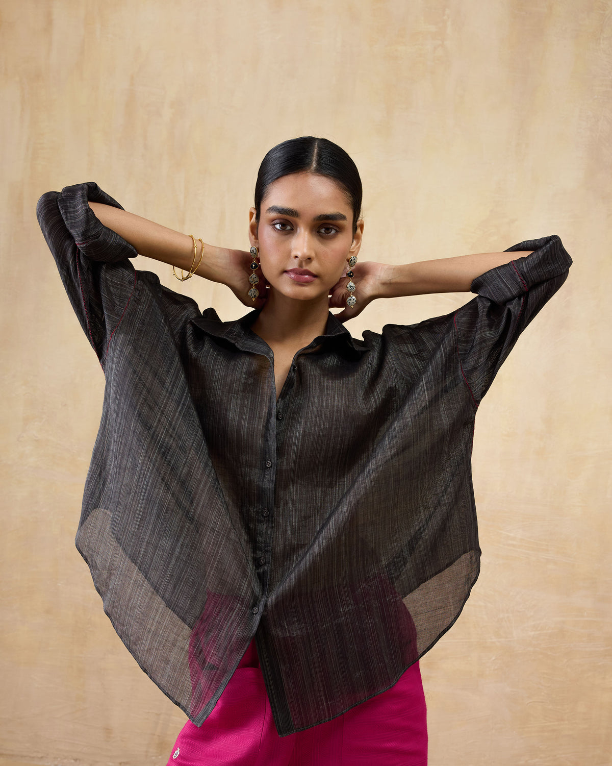 Person wearing a loose black Firefly shirt in sheer metallic tissue.