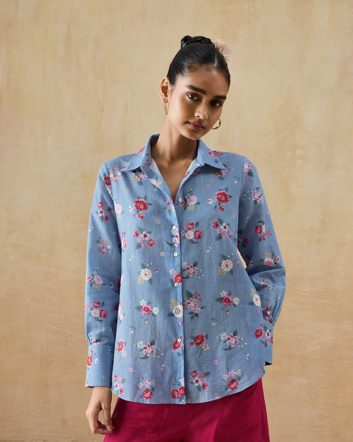 Person wearing an ice blue Detour shirt with buttoned cuffs and a curved hem.