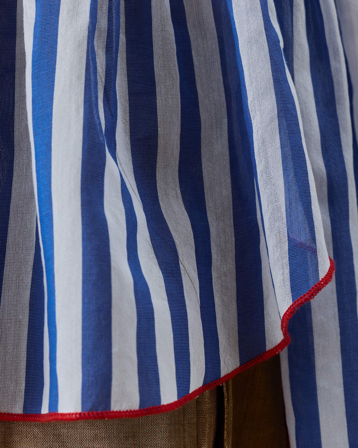 Close-up of a cobalt striped top with a red contrast hem.