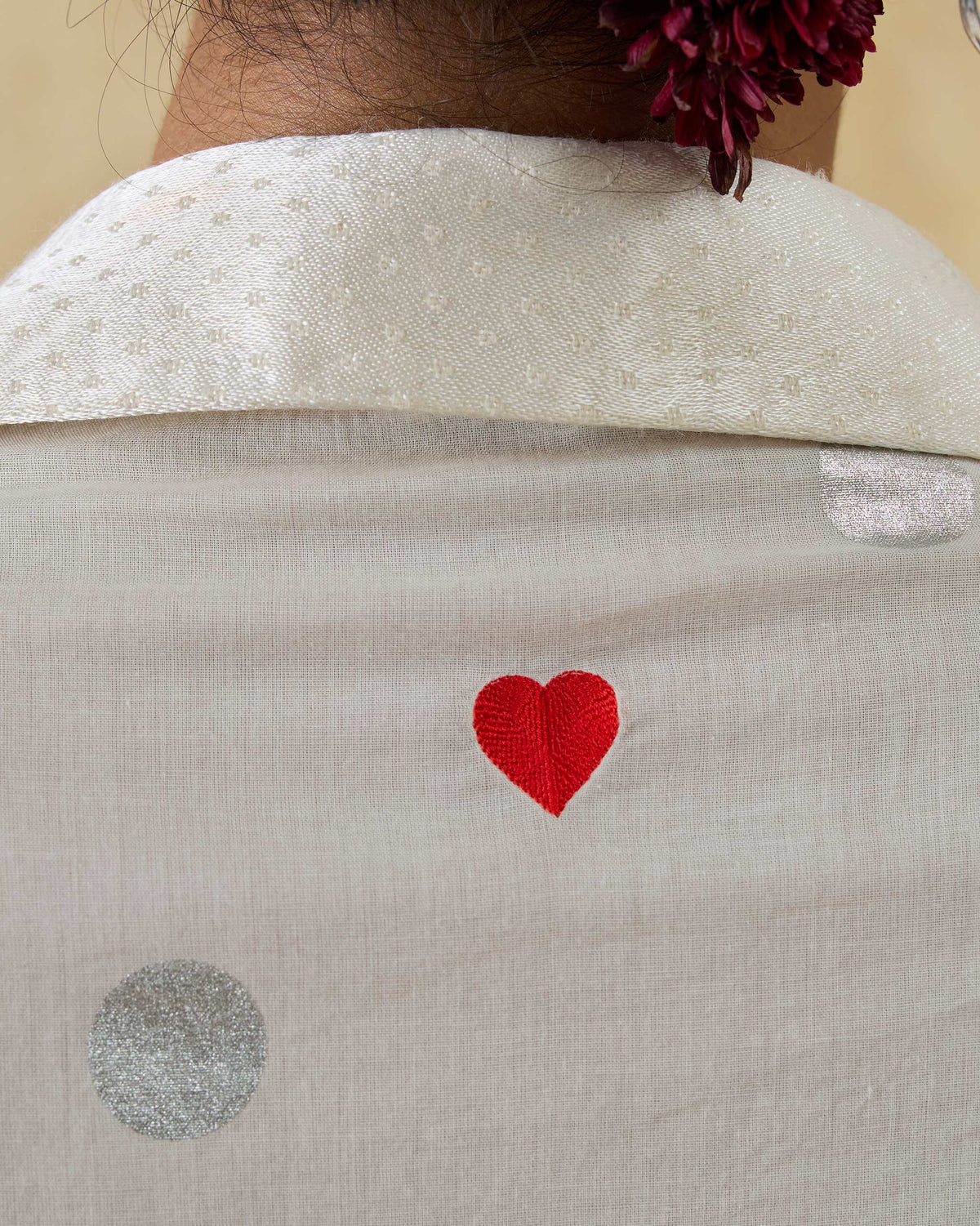 Close-up of a red heart on an ivory Rejoice kurta with silver dots.