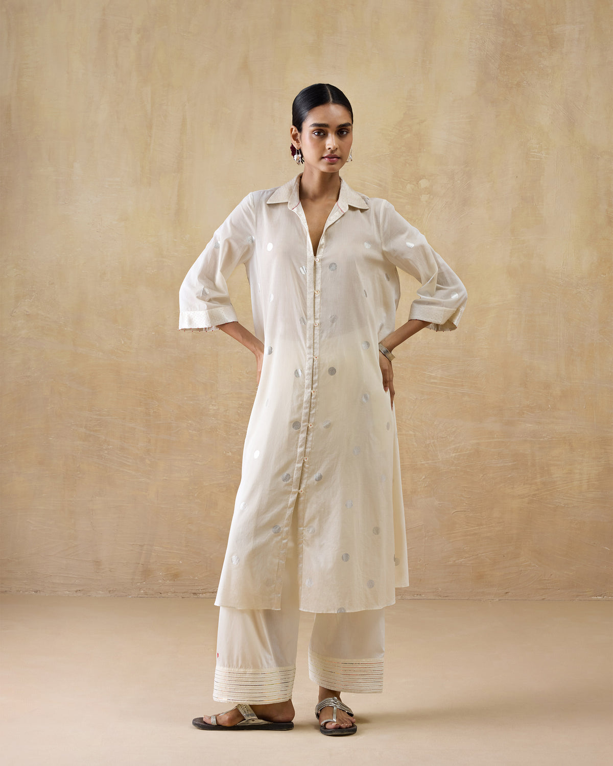 Person wearing an ivory Rejoice kurta with silver polka dots.
