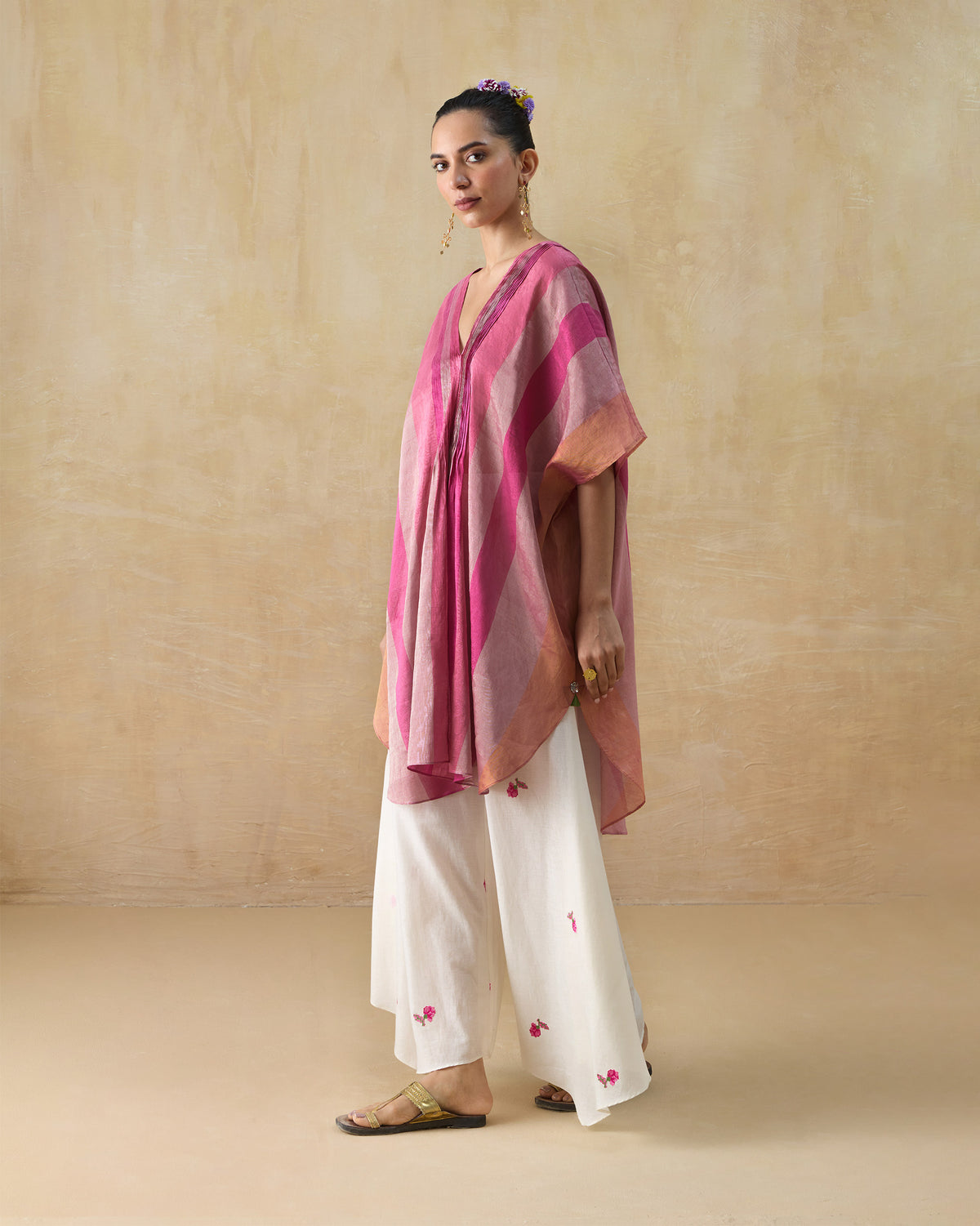 Person wearing a pink striped Jhilmil Kaftan with a V-neck and wide sleeves.
