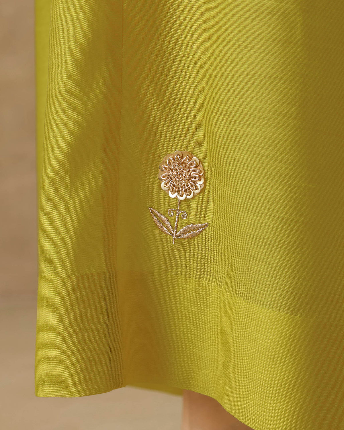 Close-up of chartreuse Basic pyjamas showing a gold floral embroidery.
