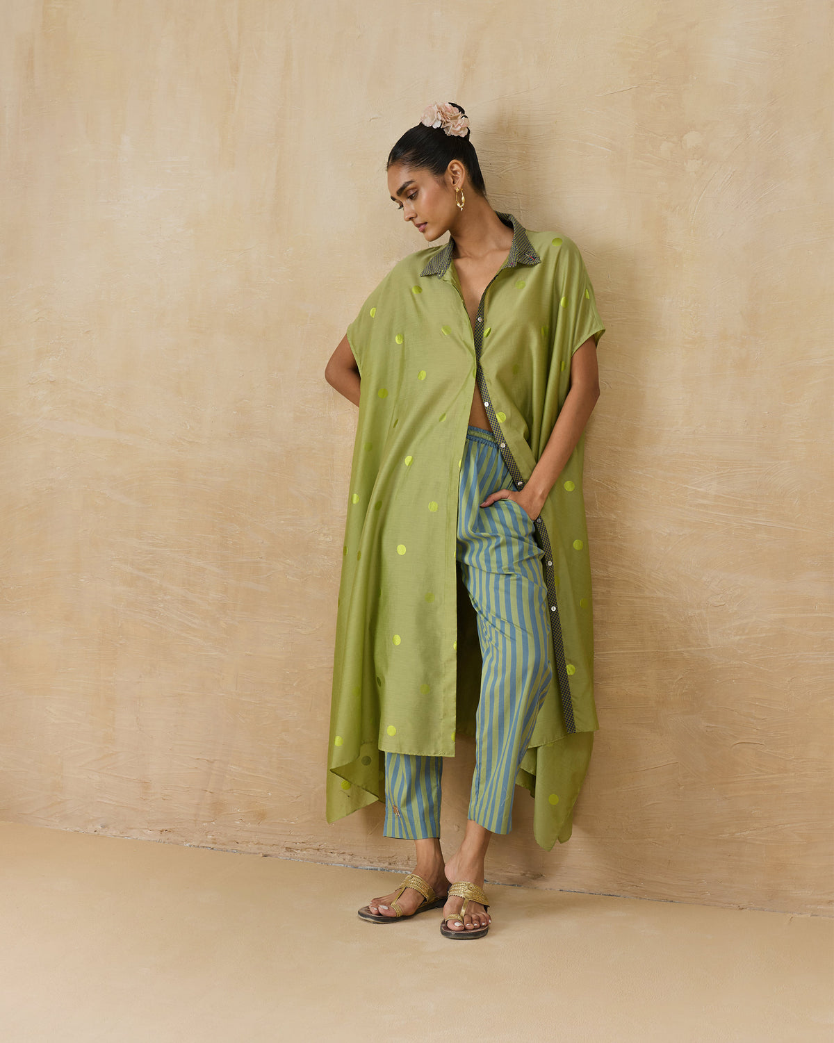 Person wearing a green polka-dot kaftan with a contrast collar.
