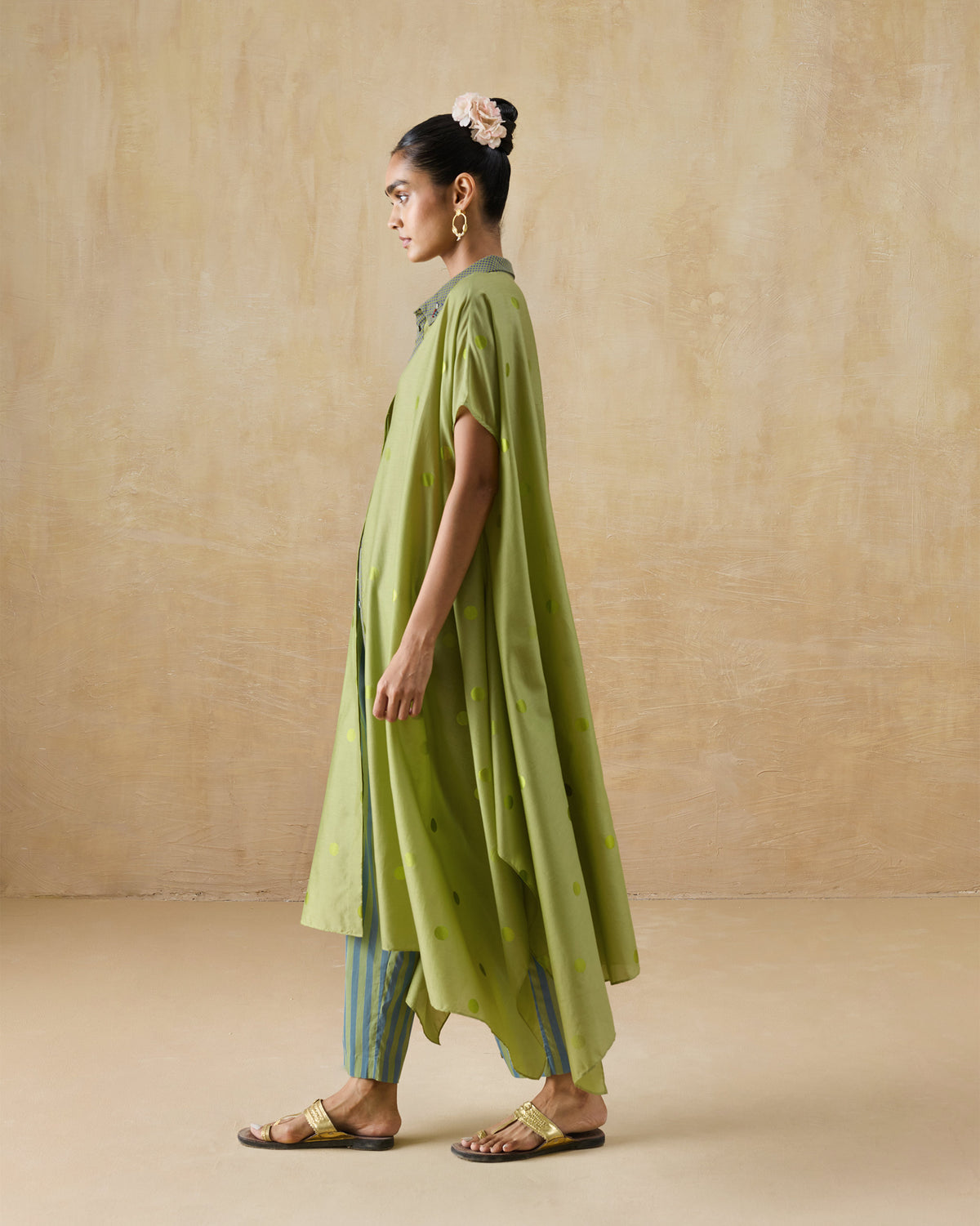 Side view of a green polka-dot kaftan with a flared hem.