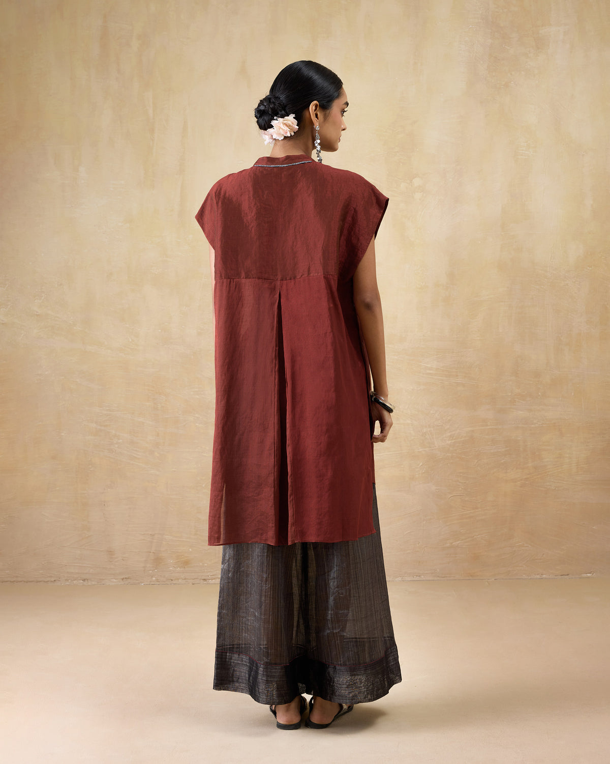 Back of a scarlet red metallic tissue kaftan with a deep center pleat.