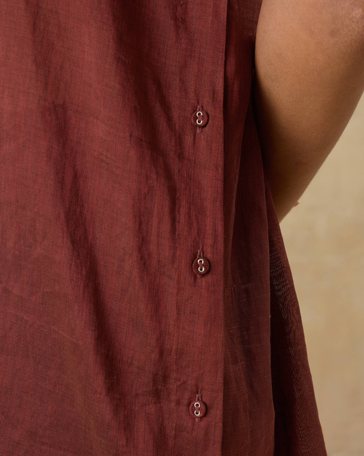 Close-up of scarlet red metallic tissue kaftan showing small placket buttons.