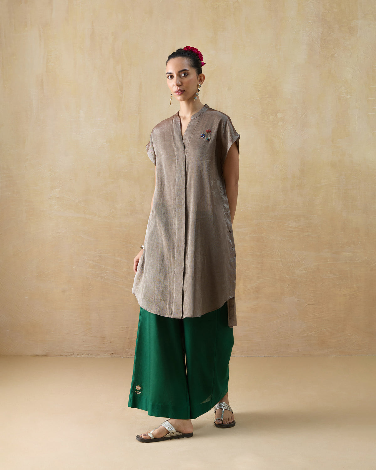 Person wearing a silver metallic kaftan with cap sleeves and shoulder embroidery.