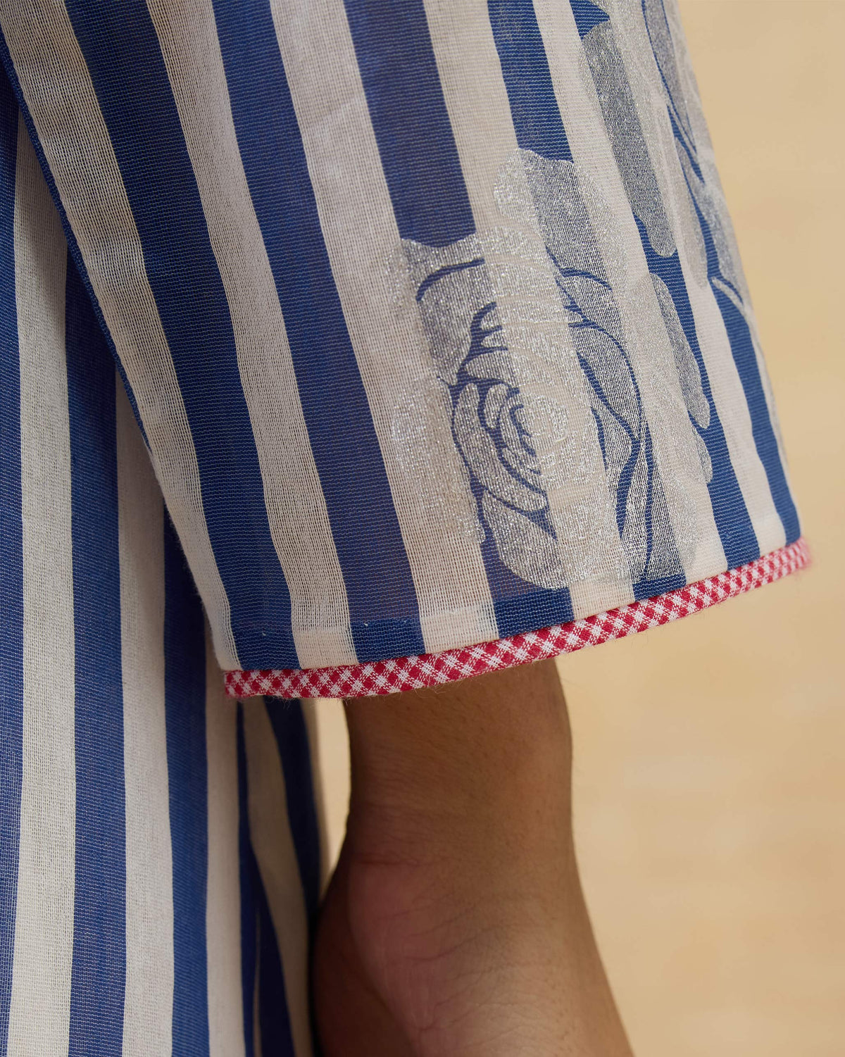 Close-up of a striped sleeve with silver roses and a checkered cuff.