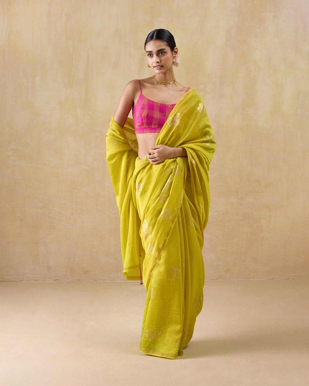 Person wearing a chartreuse Sunset sari with gold floral foil print.