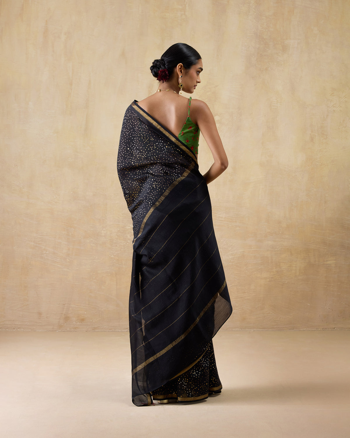 Back of a black and gold Riverbank sari with a speckled pallu and gold border.
