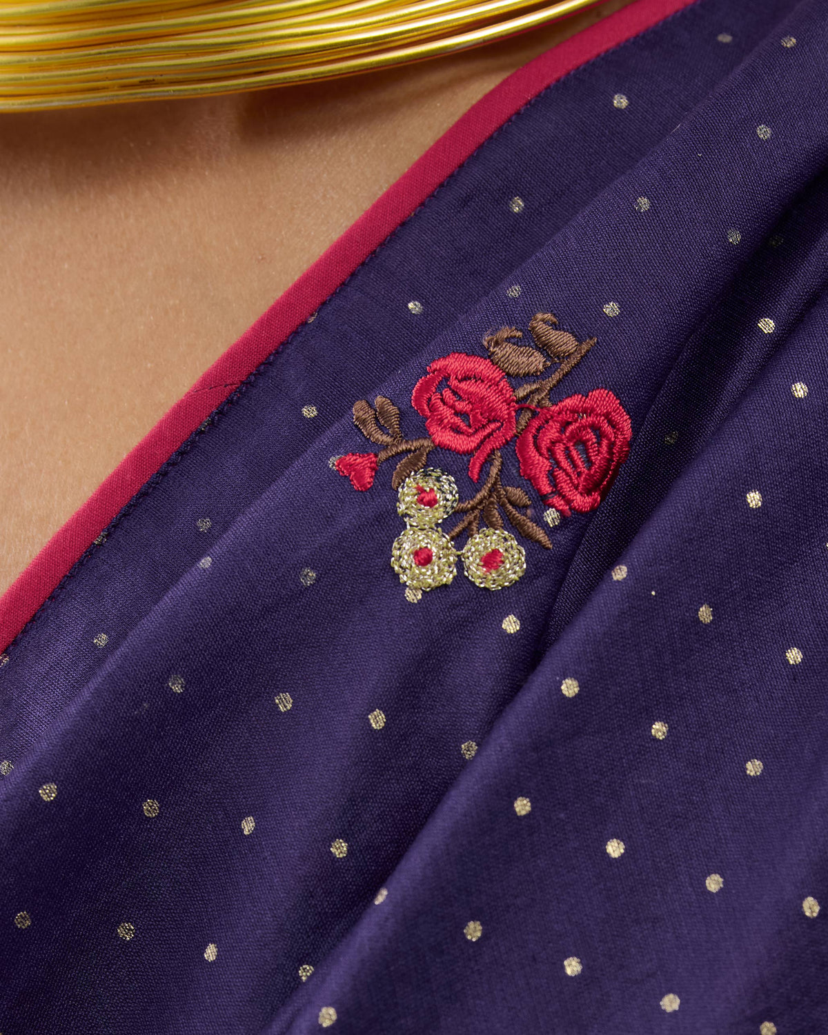 Close-up of gold dots and red floral embroidery on a purple Midnight Dance Sari.