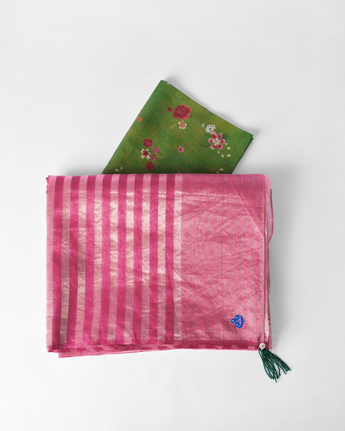 Blush pink metallic tissue Blush sari folded to show silver stripes and a green tassel.