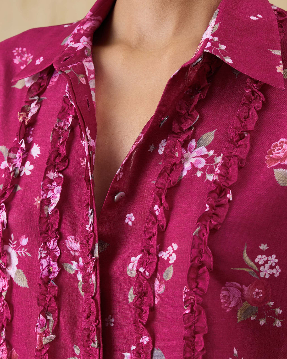 Close-up of front ruffles on a berry floral Kaveri shirt.