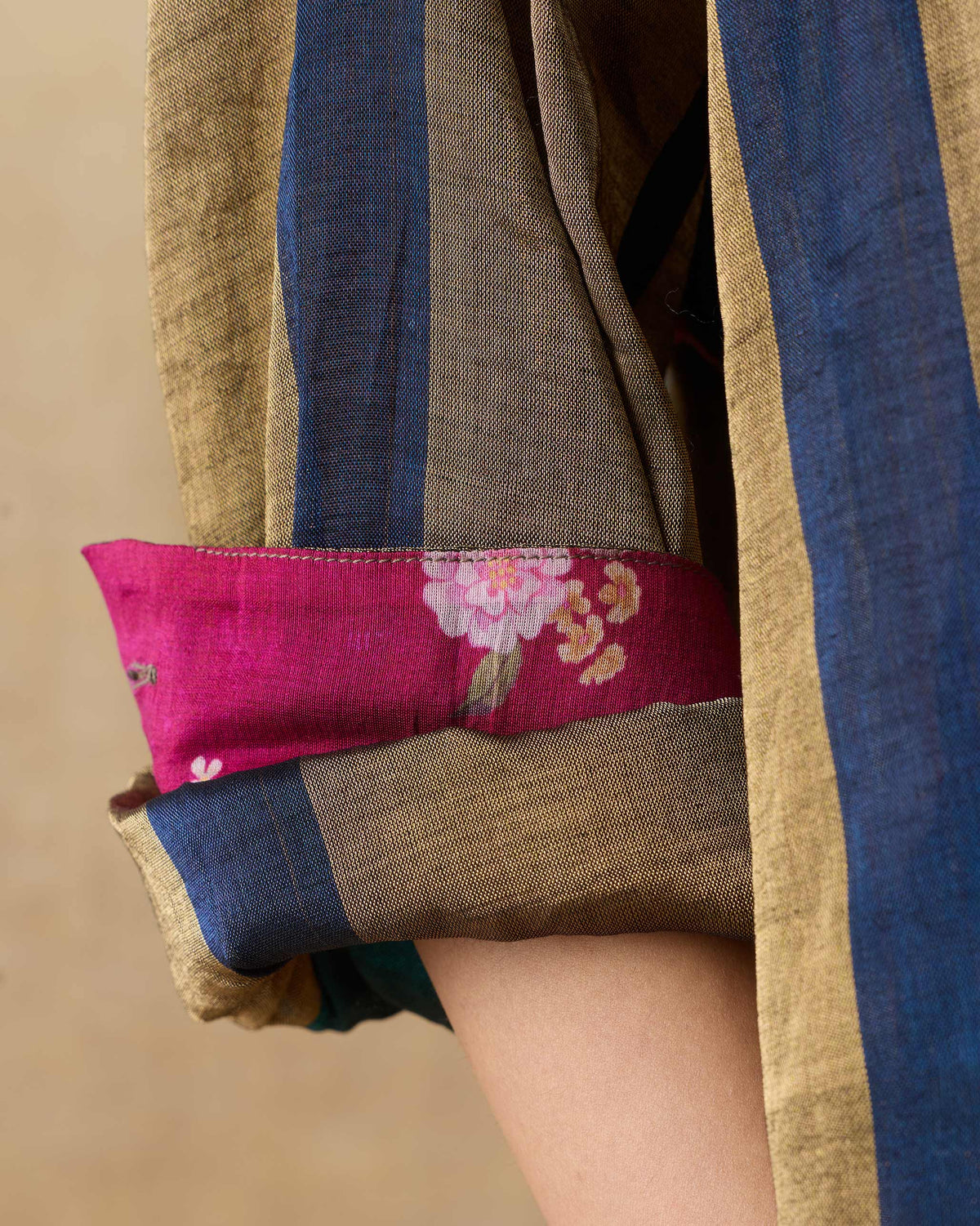 Close-up of a rolled Firefly shirt sleeve showing magenta floral lining.