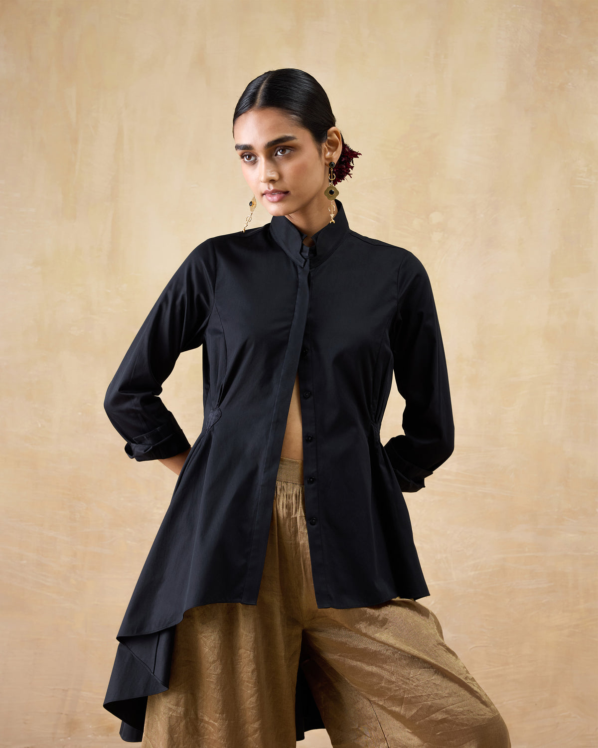 Person wearing a black Rai top with a mandarin collar and asymmetrical hem.