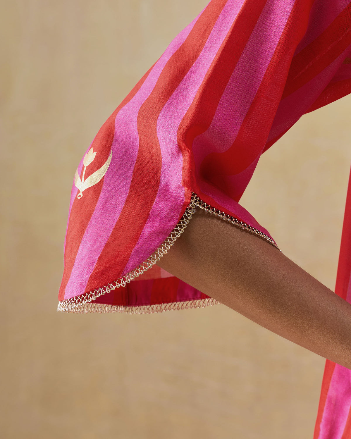 Close-up of a Galaxy kurta sleeve with a gold tulip motif and lace cuff trim.