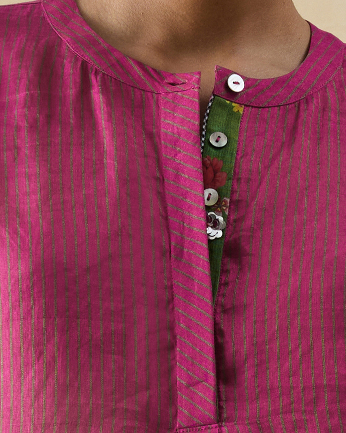 Close-up of a fuchsia Lazy Sunday tunic placket revealing green floral lining.