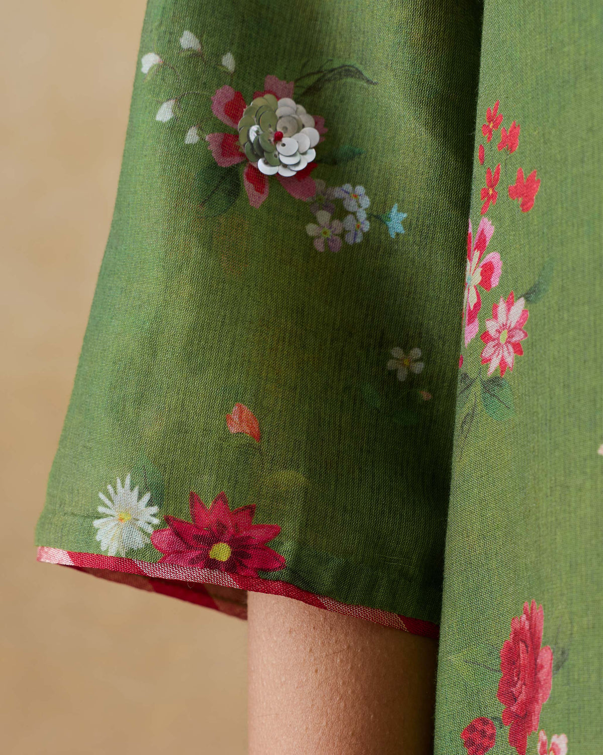 Close-up of an olive green Cascade Kurta sleeve with sequined floral details.