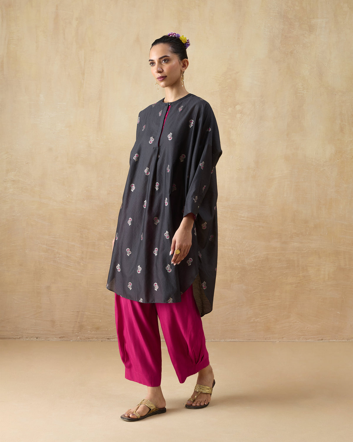 Three-quarter view of a charcoal Lazy Sunday tunic with pink floral motifs and wide sleeves.
