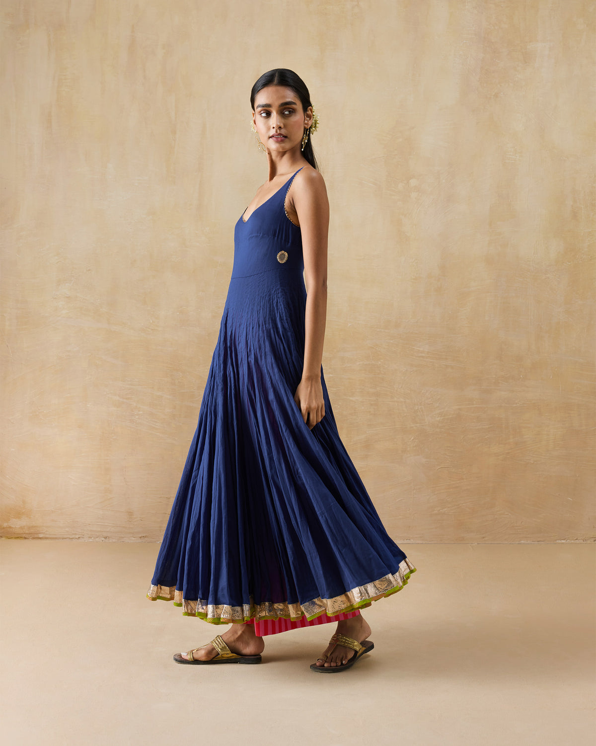 Side view of a navy Kochi kurta with a flared skirt and gold hem.