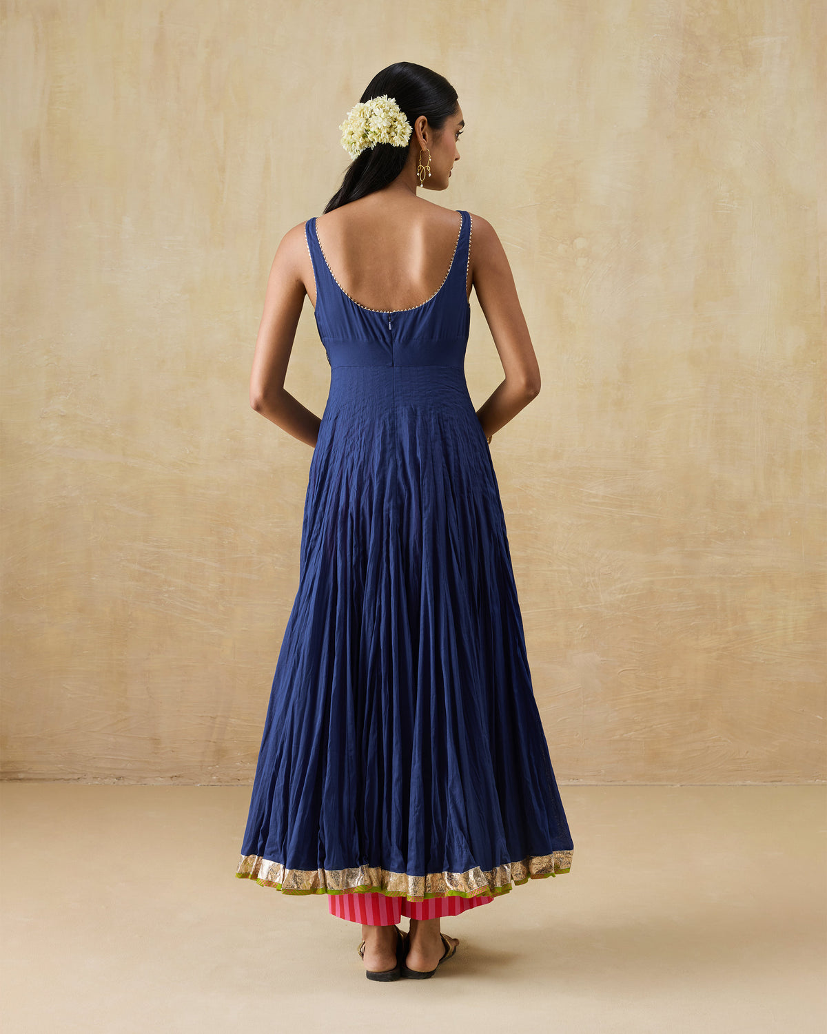 Back of a navy Kochi kurta with a scoop neckline and gold hem border.
