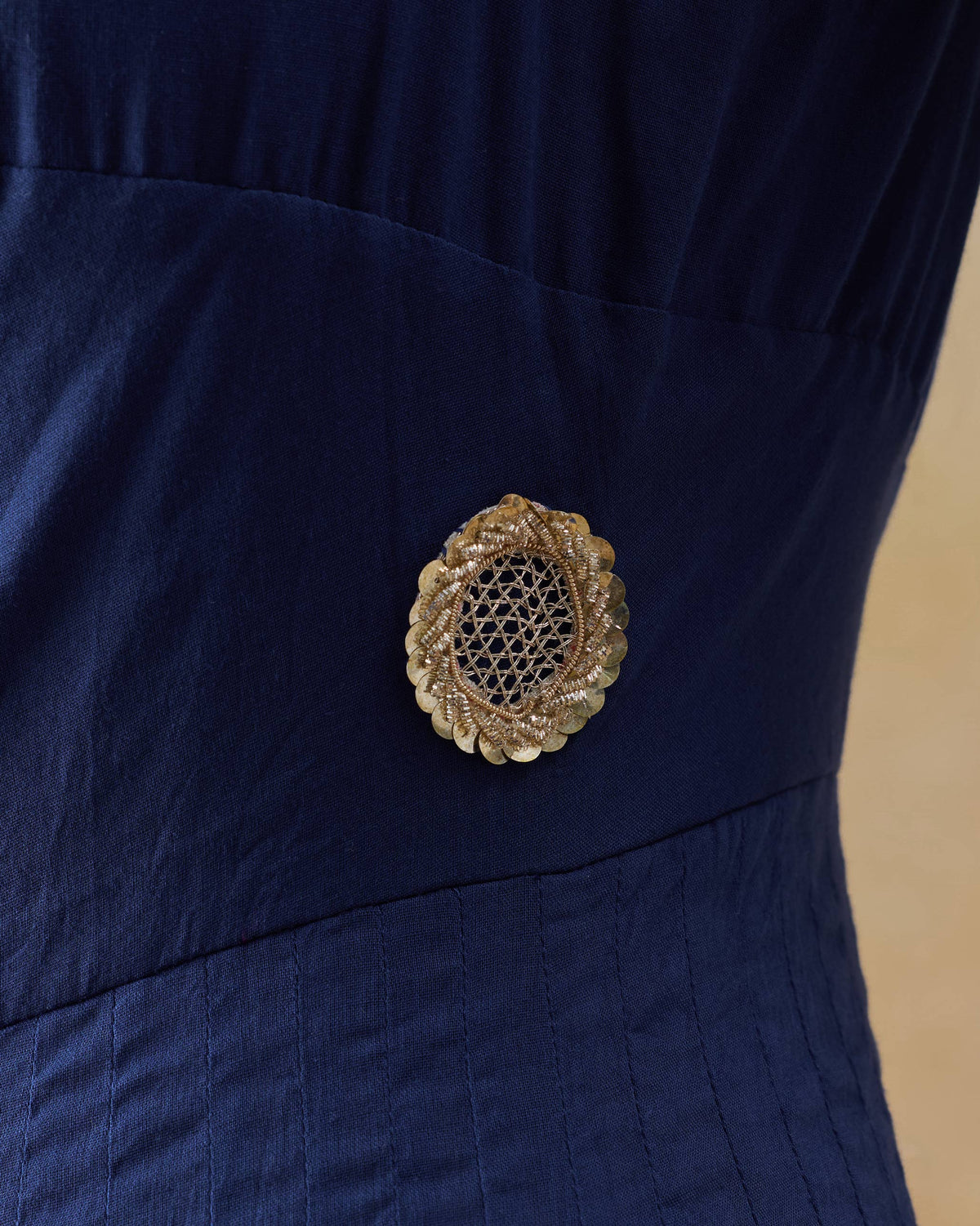 Close-up of a gold jali flower motif on the navy Kochi kurta.