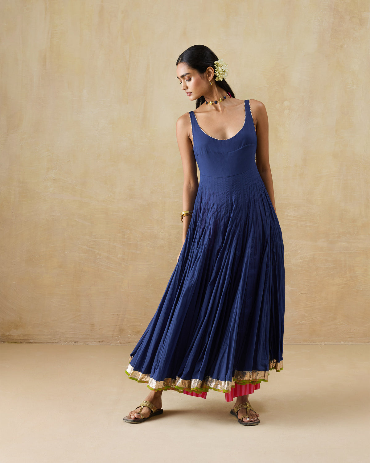 Person wearing a navy Kochi kurta with a flared skirt and gold hem border.