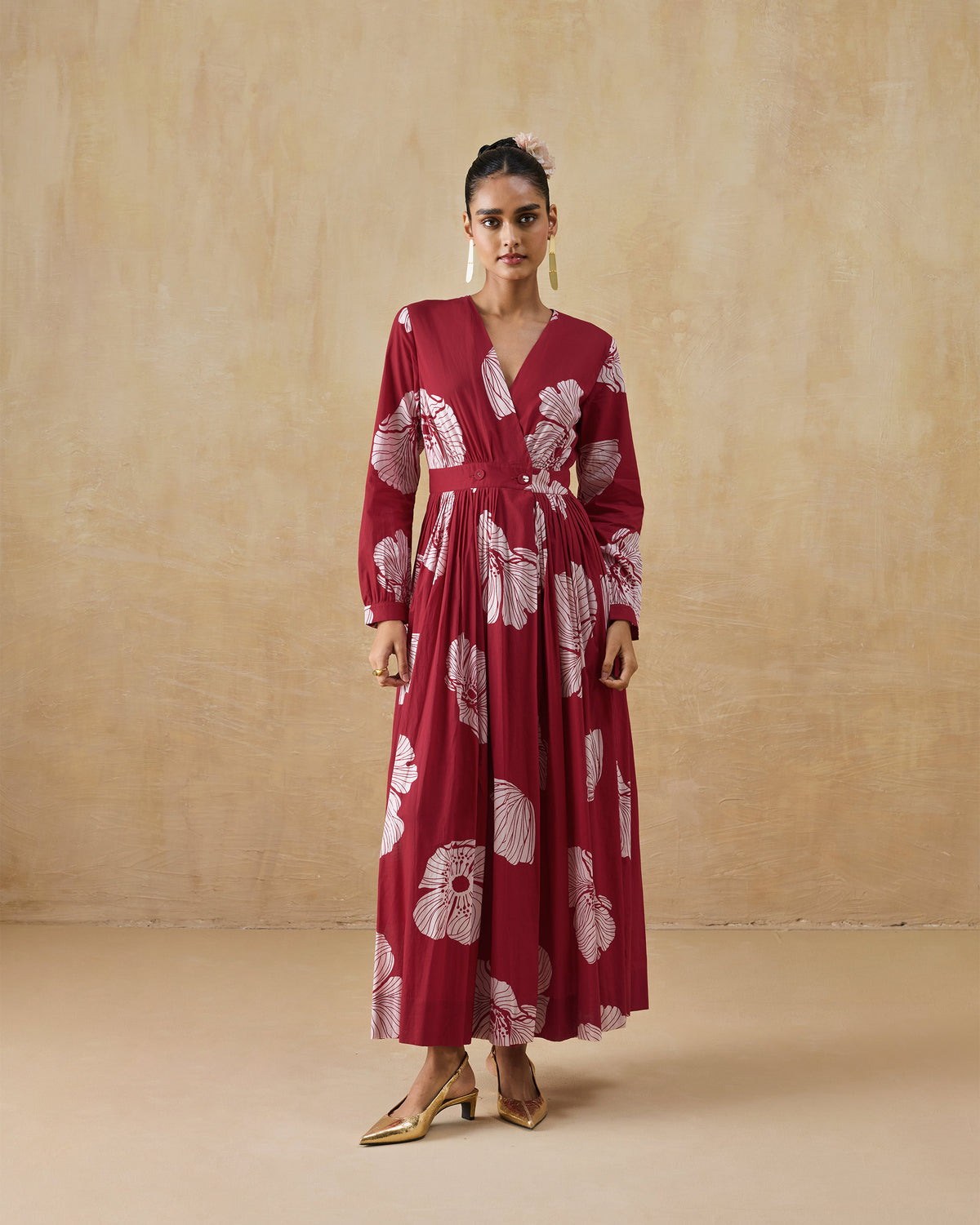 Person wearing a red and ivory Nico dress with long sleeves and a white floral print.