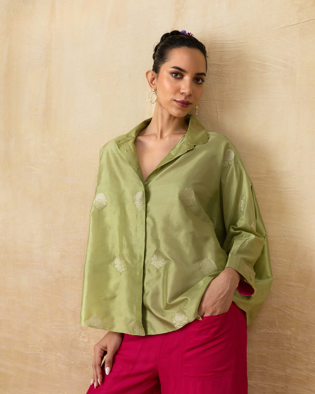 Person wearing a leaf green Boxy shirt with silver butta motifs.